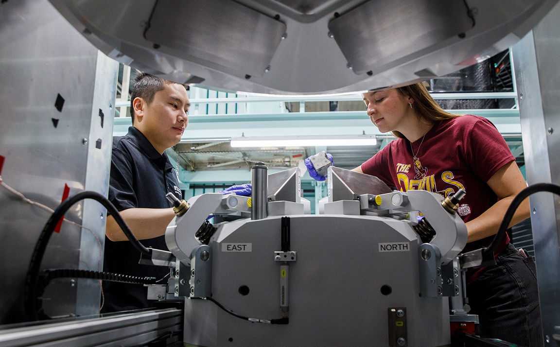 Two researchers work on a piece of equipment in one of ASU's Core Research Facilities